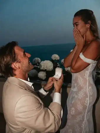 A marriage proposal by the sea with an open ring box.