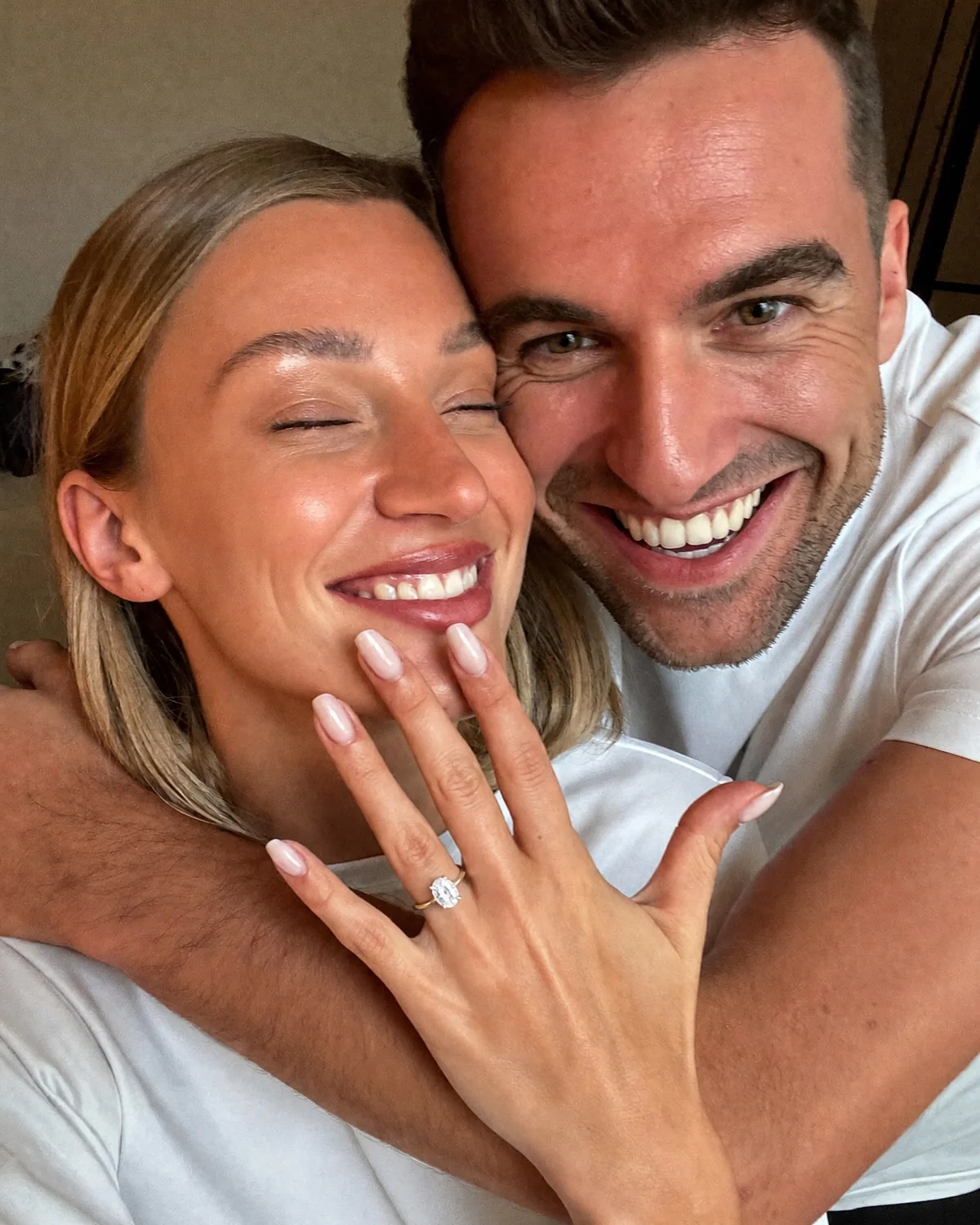 Frisch verlobtes Paar zeigt den Ring in einem spontanen Selfie
