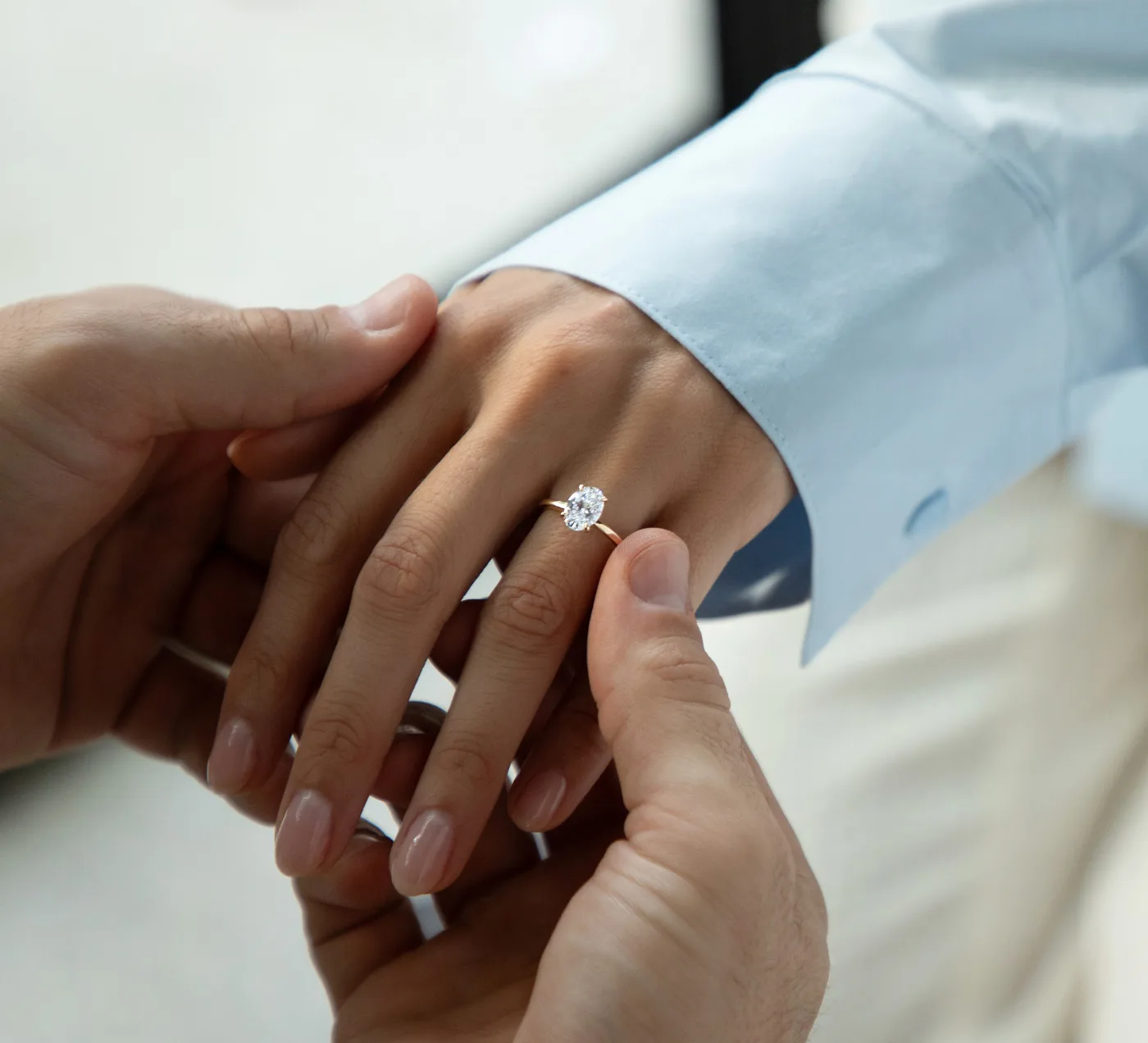Ein Mann steckt seiner Partnerin einen Verlobungsring mit ovalem Labordiamanten an.