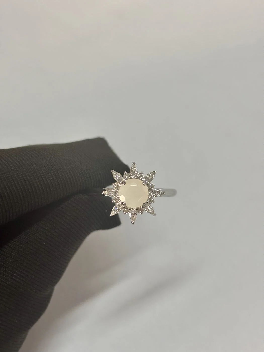 Maßgefertigter Velur Mondstein-Halo-Ring in 14k Weißgold bei der Endkontrolle in der Werkstatt