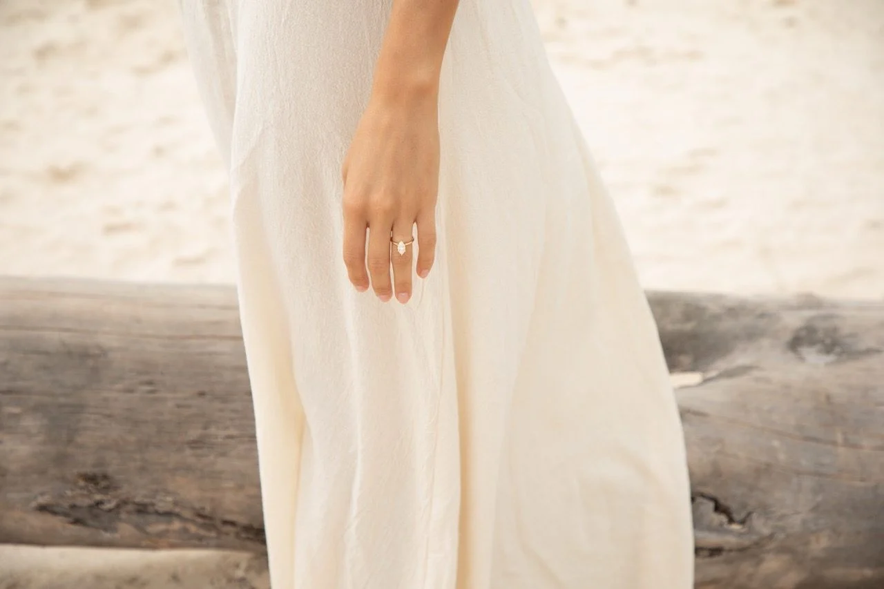 Hand mit Verlobungsring am Strand, Überraschungsantrag