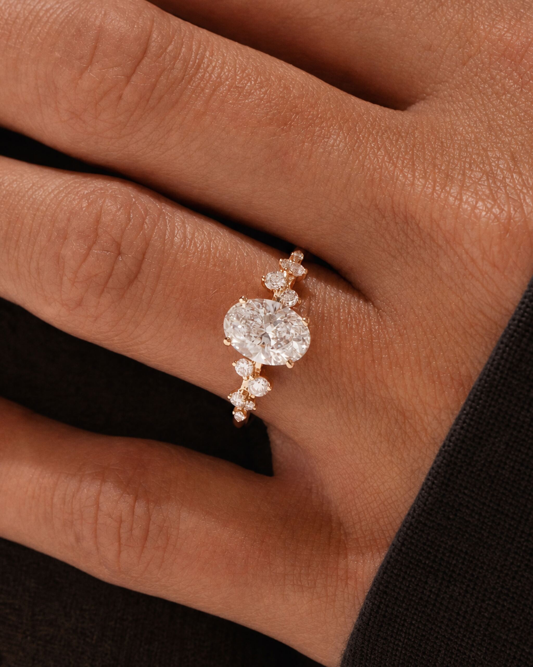 Floral Verlobungsring in Gelbgold mit floralen Akzentsteinen an der Hand