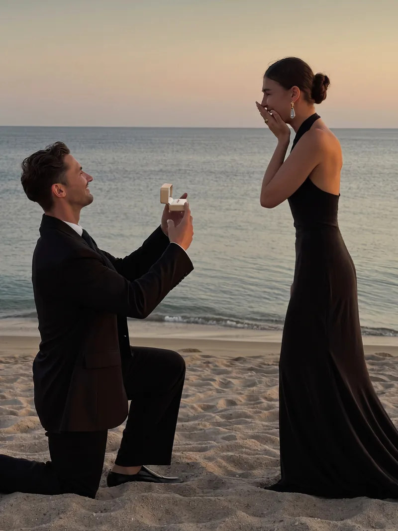 Heiratsantrag am Strand mit geöffneter Ringbox.
